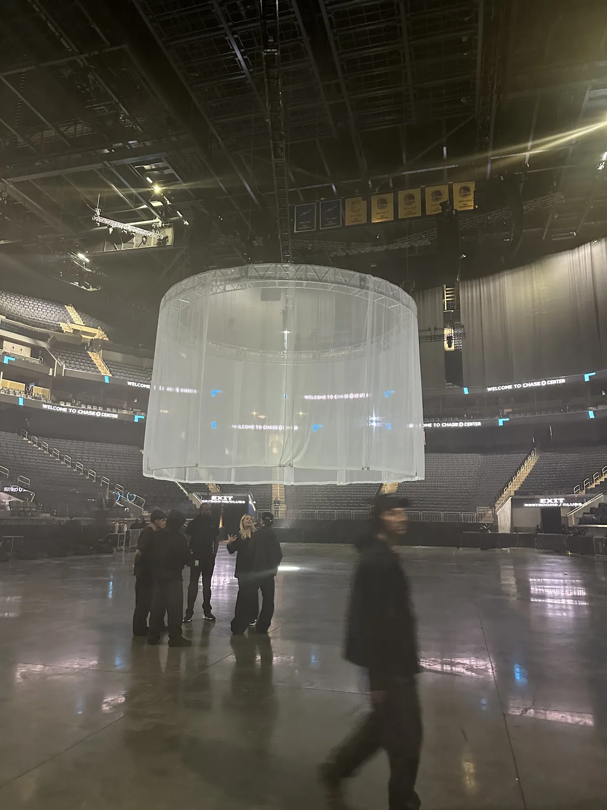 Circular translucent fabric screen hanging above the Chase Center floor before the Vultures Listening Experience