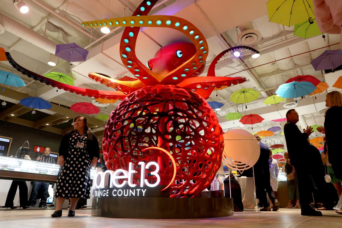 Large red octopus sculpture inside Planet 13 Orange County during the opening event