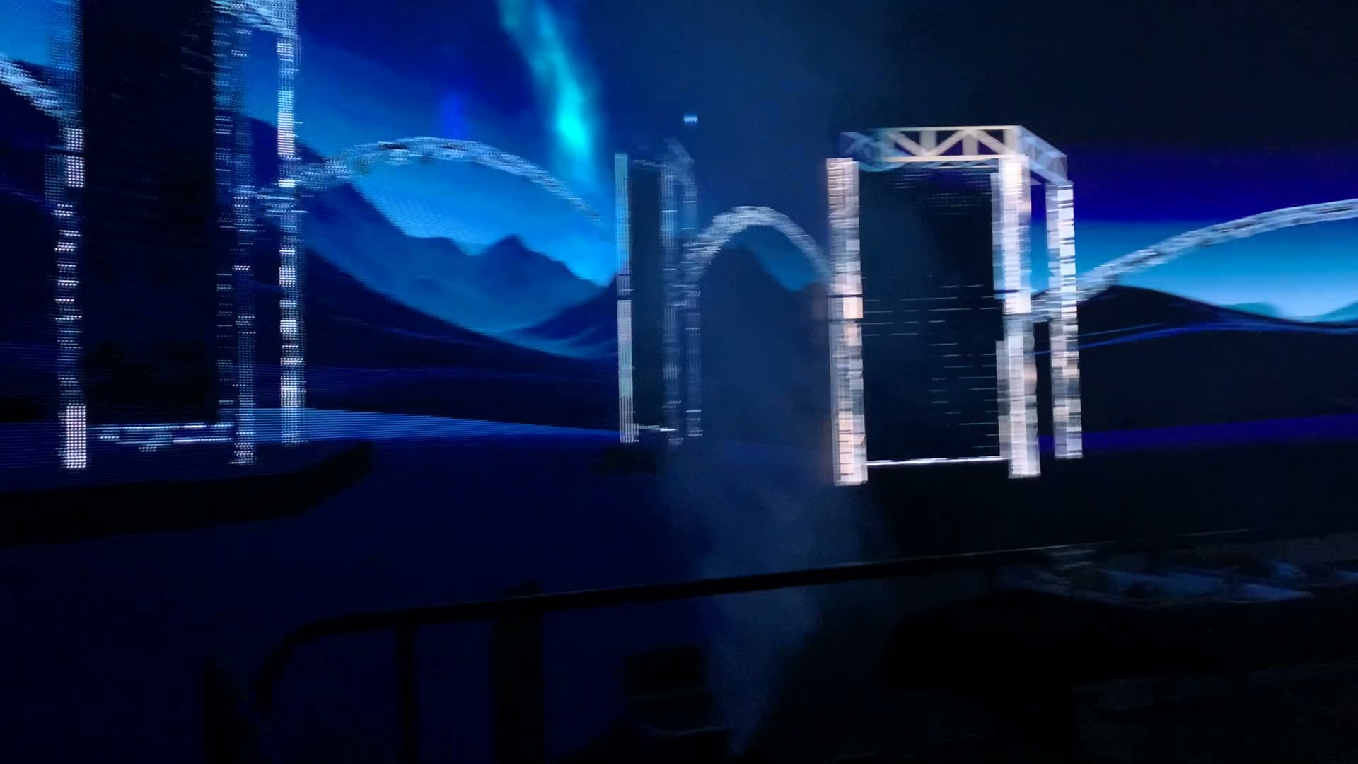Side angle of the virtual stage showing arched lighting truss and landscape environment